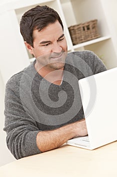 Man Using Laptop Computer At Home