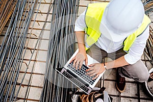 Man using laptop on construction site. Building industry details