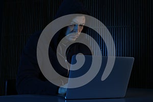 Man using laptop in dark room