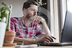 Man using laptop on desk working from home