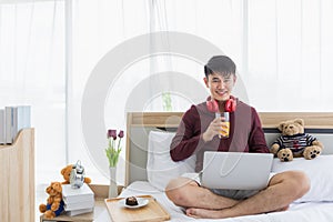 Man using laptop and drinking orange juice