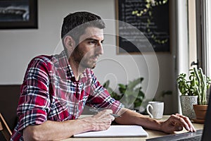 Man using laptop at home office desk