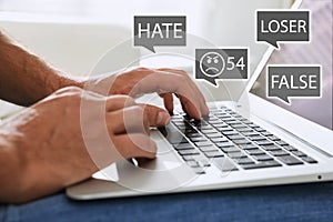 Man using laptop and icons with offensive messages, closeup. Cyber bulling concept