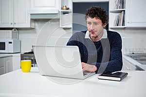 Man using laptop in the kitchen