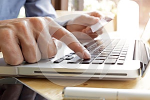 Man using laptop and mobile phone to online shopping and pay by credit card.