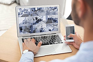 Man using laptop for monitoring CCTV cameras