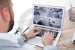 Man using laptop for monitoring CCTV cameras