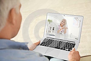 Man using laptop for online consultation with doctor via video chat at home