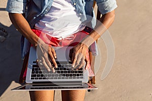 Man using laptop while relaxing in a beach chair on the beach