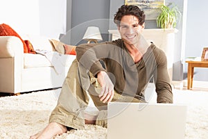 Man Using Laptop Relaxing Laying On Rug At Home