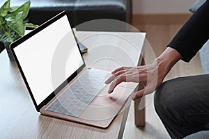 Man using laptop on wooden table.