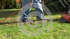 A man using a lawn aerator in the garden