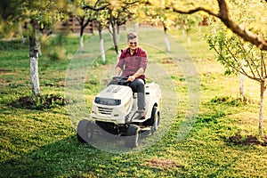 man using lawn mower and cutting grass during landscaping works