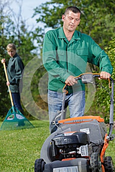 man using lawnmower and girl wiping