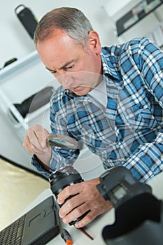 Man using magnifing glass with camera