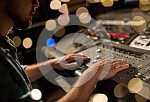 Man using mixing console in music recording studio