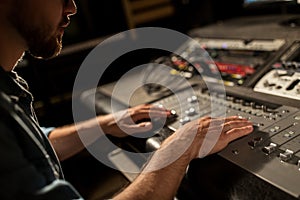 Man using mixing console in music recording studio