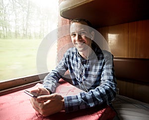 Man using mobile application on his smartphone at train station, business travel.
