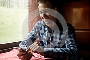 Man using mobile application on his smartphone at train station, business travel.