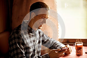 Man using mobile application on his smartphone at train station, business travel