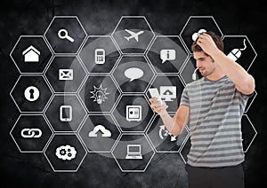 Man using mobile phone against application icons on black background