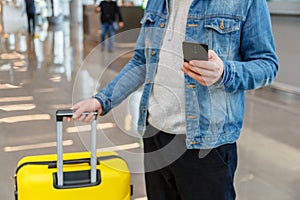 Man using mobile phone at airport. Urban traveler wearing casual holds smartphone, guy texting message while holding