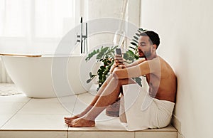 Man using mobile phone in bathroom