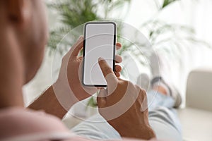 Man using mobile phone with empty screen indoors, closeup