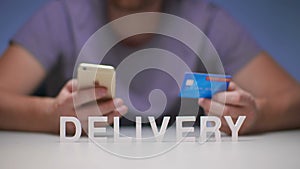 Man using mobile phone orders delivery food to house and payment by credit card