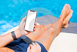 Man using mobile phone on vacation by the pool. Mobile phone mockup.