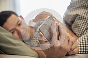 Man using mobile phone while wake up on bed in the morning