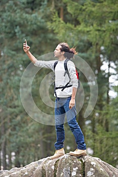 Man Using Mobile Phone Whilst Hiking In Countryside