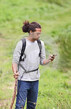 Man Using Mobile Phone Whilst Hiking In Countryside