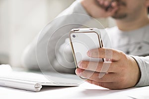 Man using mobile phone while working on desktop