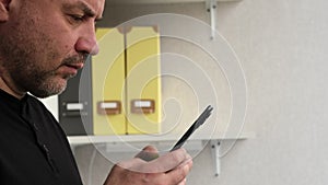 Man using mobile smart phone in office side view. Businessman holding smartphone