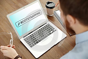 Man using modern laptop at table. Bootstrap button photo