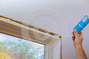 Man in a using a mounting foam window installation