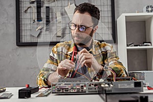 man using multimeter while fixing