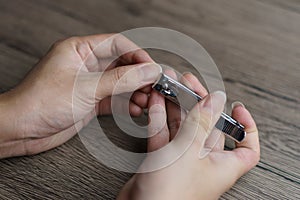 Man using nail clipper clipping her fingernails