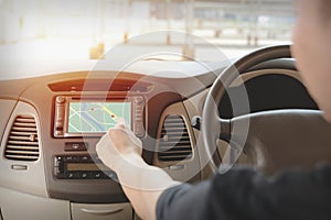 Man using navigation system while driving a car. GPS navigation panel on dashboard inside a car. Finger pointing on destination