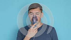 Man using nebuliser with breathing mask inhaling medication