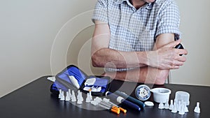 A man using a non-invasive glucose meter to measuring glucose level blood