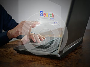 A man is using a notebook computer to searching for information. A virtual screen of the Search website browser for finding data