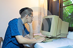 A man using an old personal computer .