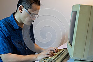 A man using an old personal computer .