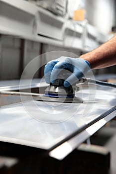 Man using orbital sander on metal