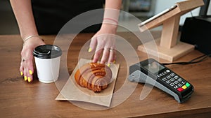 Man using payment terminal in cafeteria. Restaurant. Croissant and coffee.
