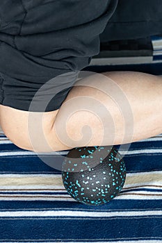 a man using peanut-shaped massage balls to relax his anterior tibialis at vertical composition