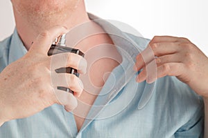 Man using perfume on white background