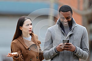 Man using phone ignoring her friend in the street